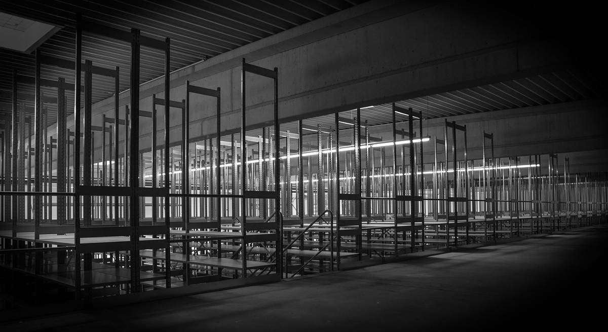 Des rangées de cadres métalliques dans une salle industrielle sombre, éclairée Des rangées de cadres métalliques dans une salle industrielle sombre, éclairée